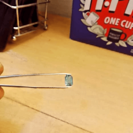 Certification gemstone held for inspection